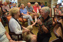 Music-004R-220x147 a group of people sitting in chairs and talking to a dog